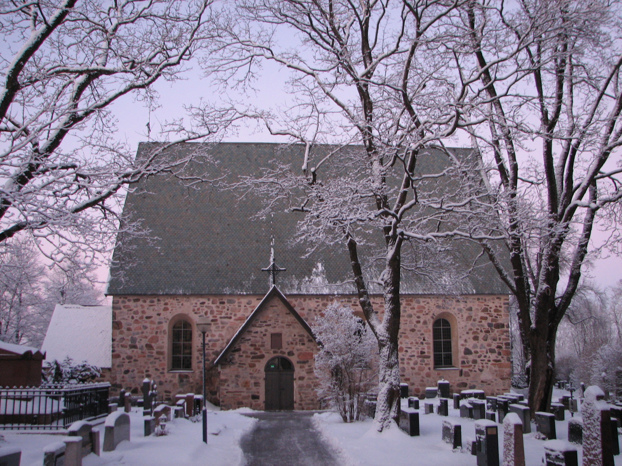 Pyhän Katariinan kirkko talvimaisemassa. Kirkkomaalla lumipeite.