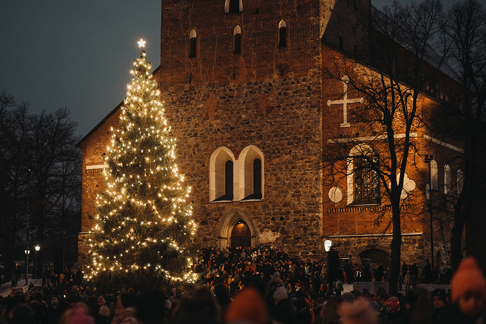 Valaistu joulukuusi Turun tuomiokirkon edustalla, paljon ihmisiä.