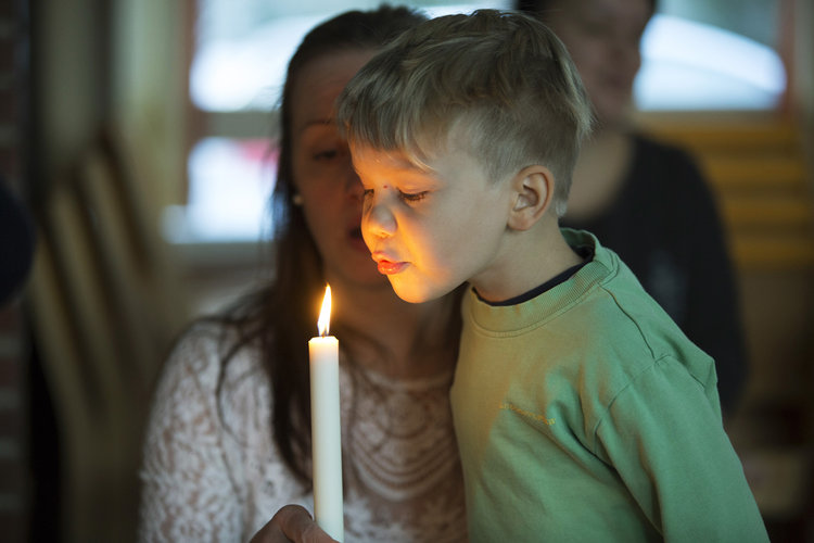 Poika puhaltaa kynttilää