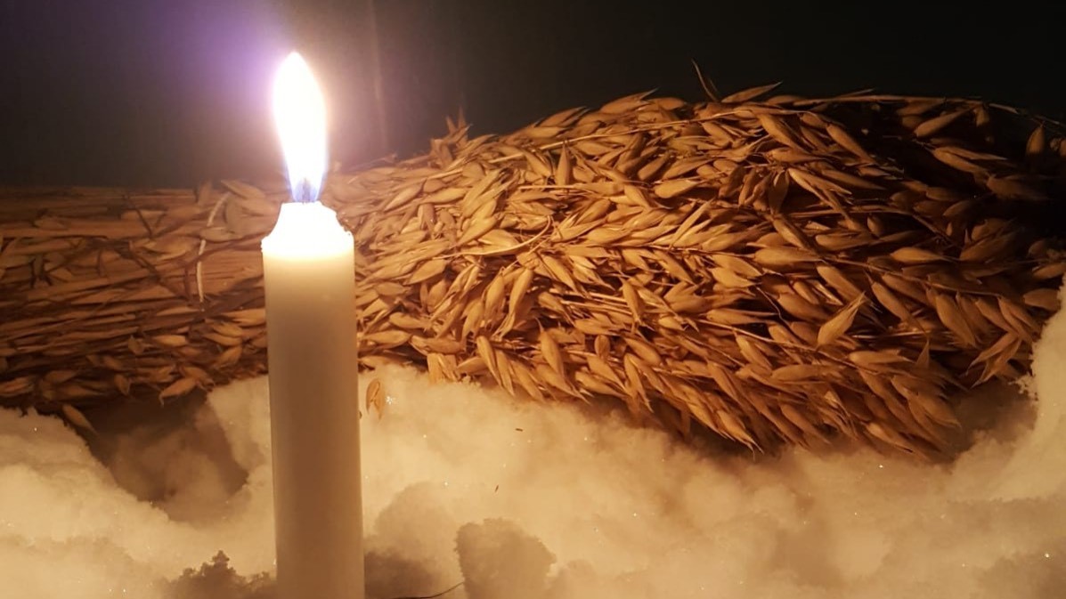 Hoosiannakirkko (myös verkossa) Yksi adventtikynttilä palaa. Maassa on lunta ja kauralyhde.