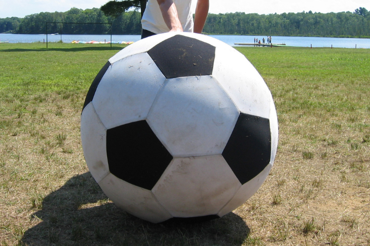 Iso jalkapallo, nurmikkoa ja ranta.