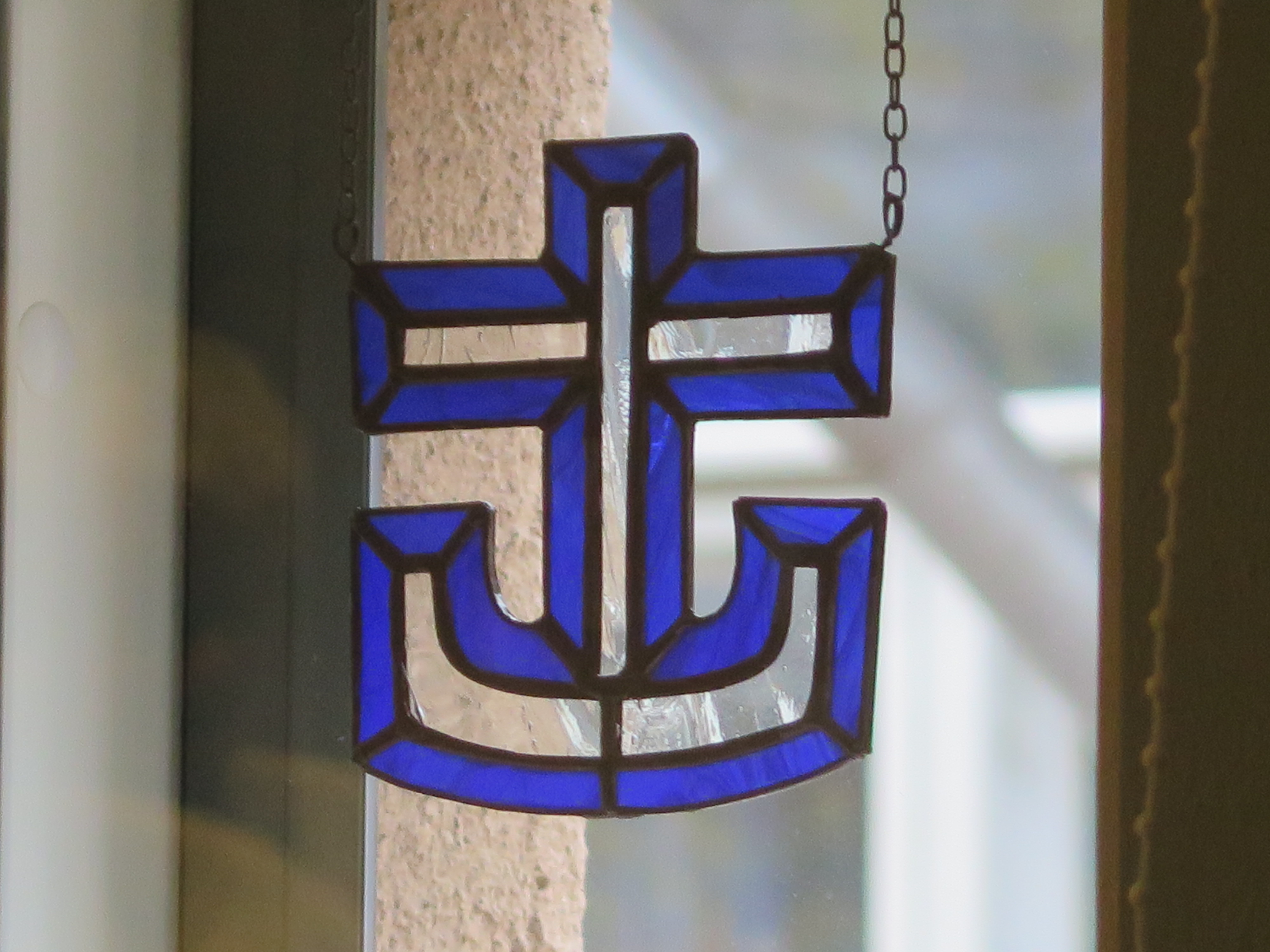 Merimieskirkon sininen tunnus Mikaelin seurakuntakodin ikkunassa.