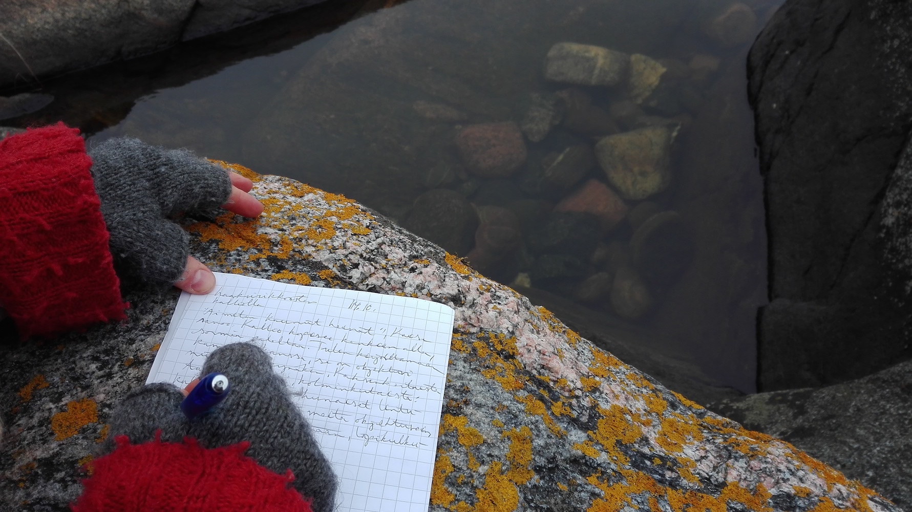 Henkilö kirjoittaa paperille