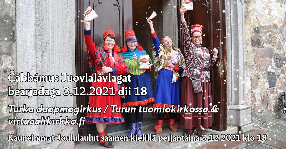 Neljä hymyilevää naista värikkäissä saamenpuvuissa Tuomiokirkon ovella lauluvihot käsissään