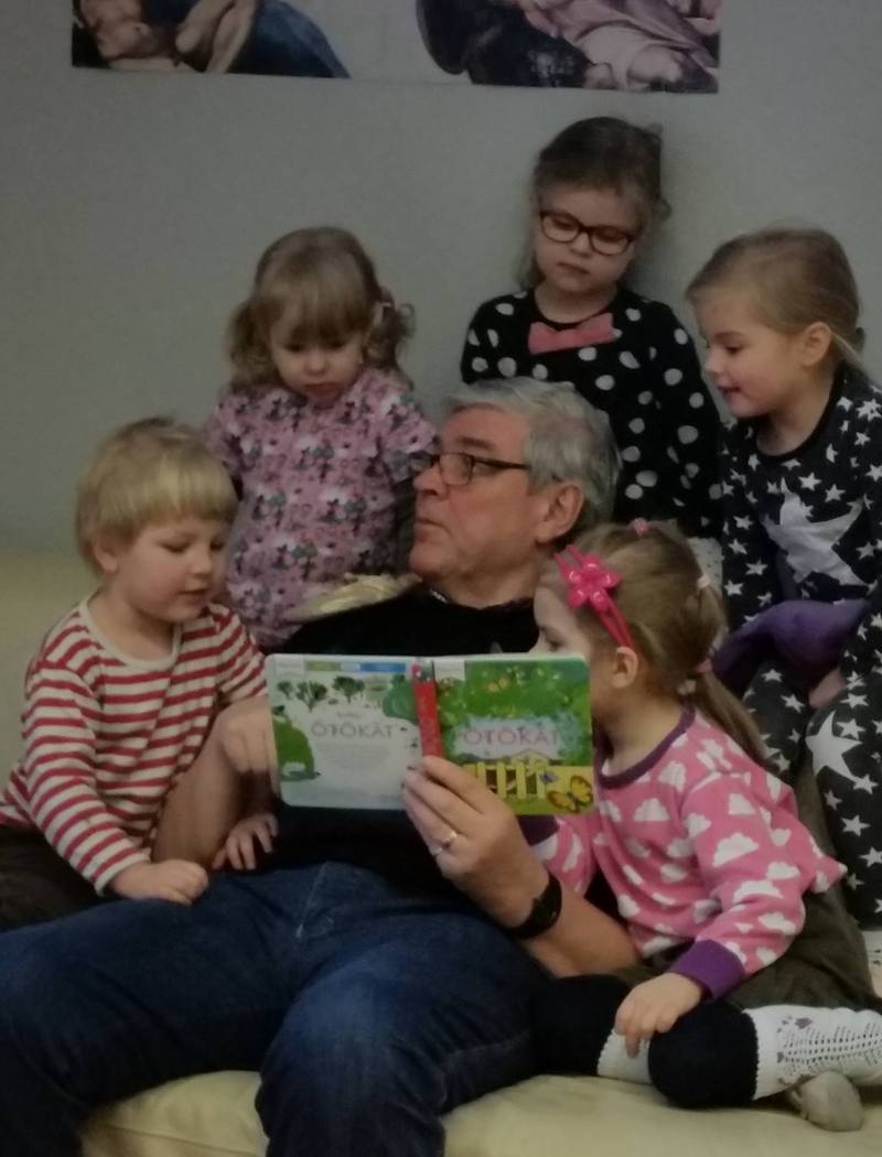 Vanhempi mies lukee lapsille satua