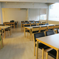 Leaf Sali, jossa valkoisia kahdeksan hengen pöytiä tuoleineen.