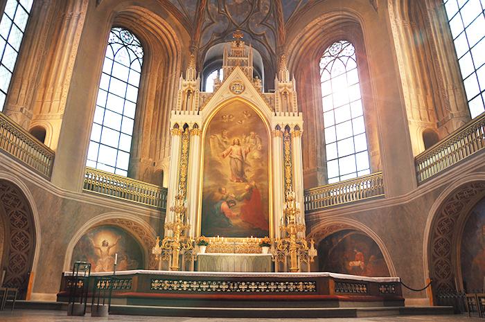 Tuomiokirkon valkoinen ja kultakoristeinen alttarirakennelma, jossa Jeesus keskellä opetuslapset jaloissaan.