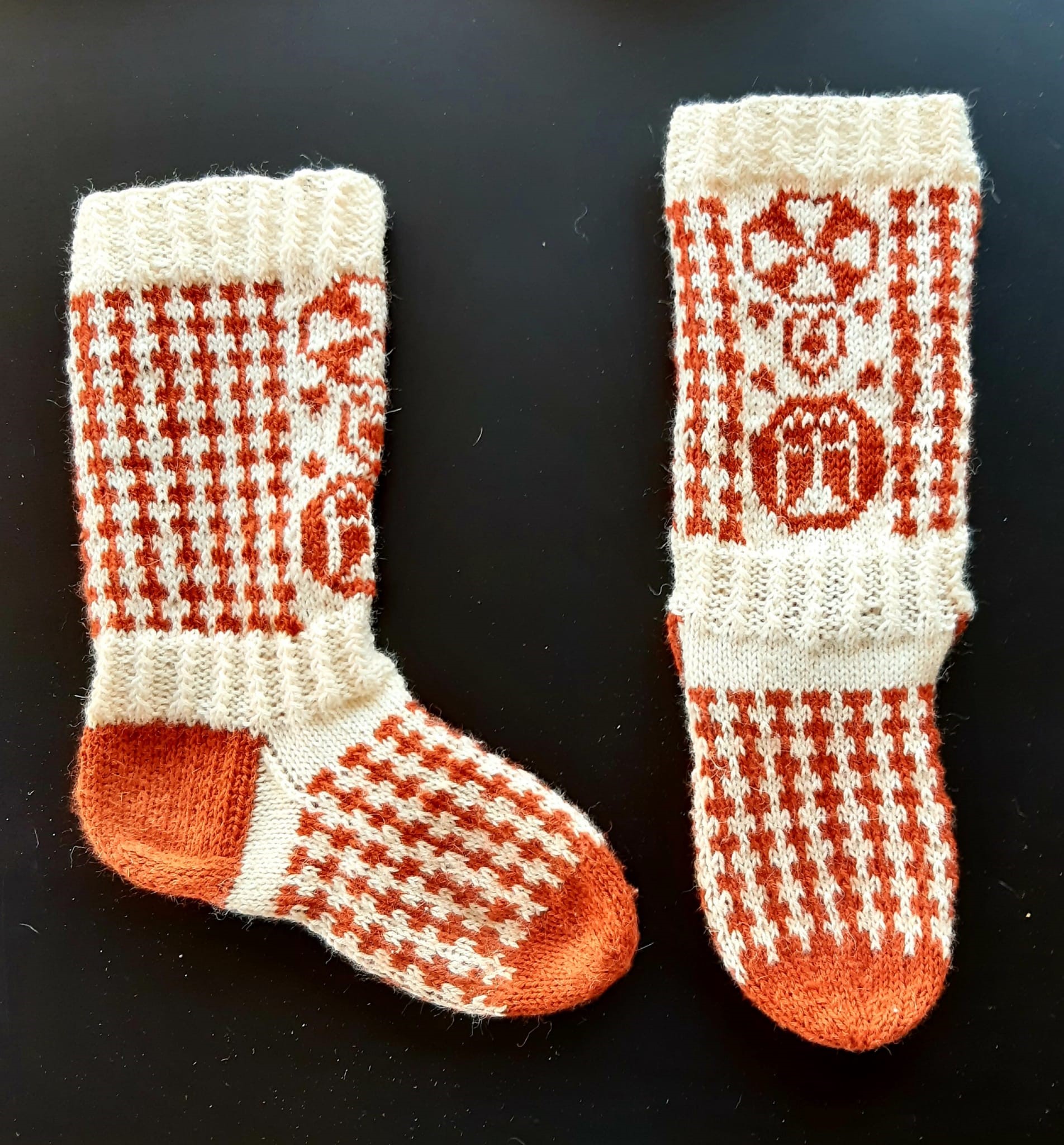 Valkoiset sukat, joissa tumman oranssilla kuvioita ja pylväitä
