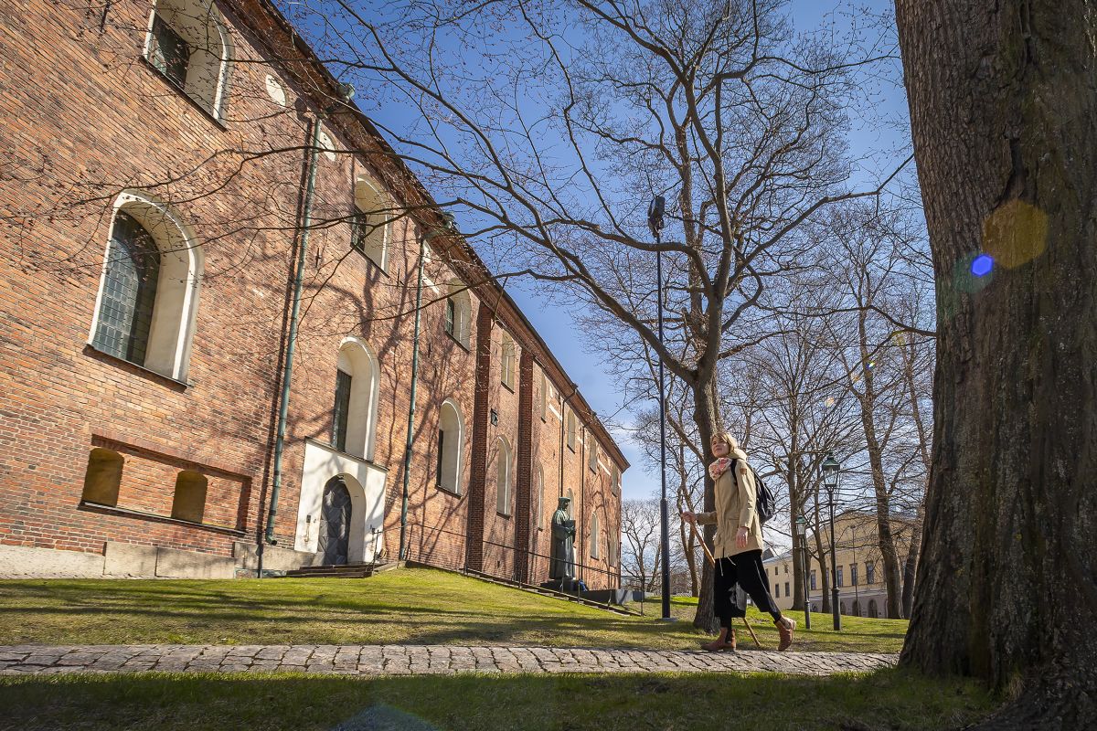 Annastiina Papinaho astelee aurinkoisen Tuomiokirkon edustalla.