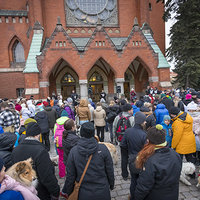 Ihmisiä ja koiria Mikaelinkirkon mäellä. 