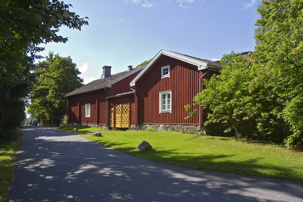 Punaiseksi maalattu puurakennus, jossa keltainen portti