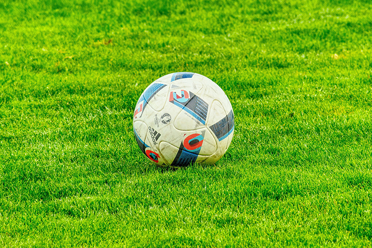 Jalkapallo vihreällä nurmikolla.