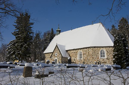 Piikkiön kirkko, maisemassa ja kirkon katolla paljon lunta.