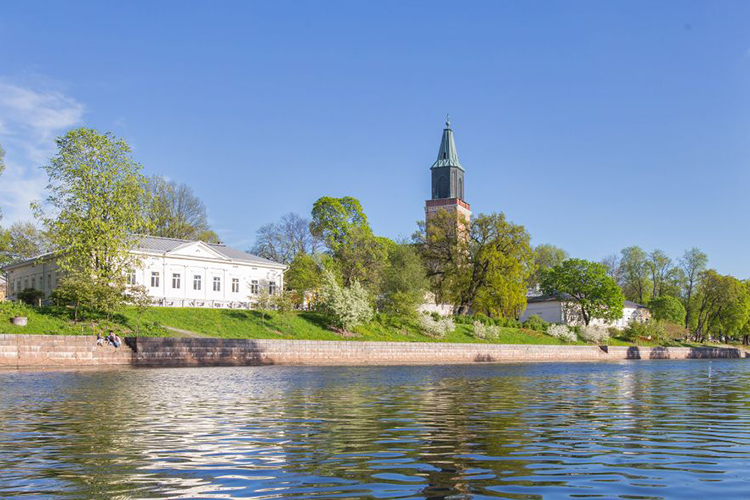 Kesäinen Turun tuomiokirkko Aurajoen toiselta puolelta kuvattuna.