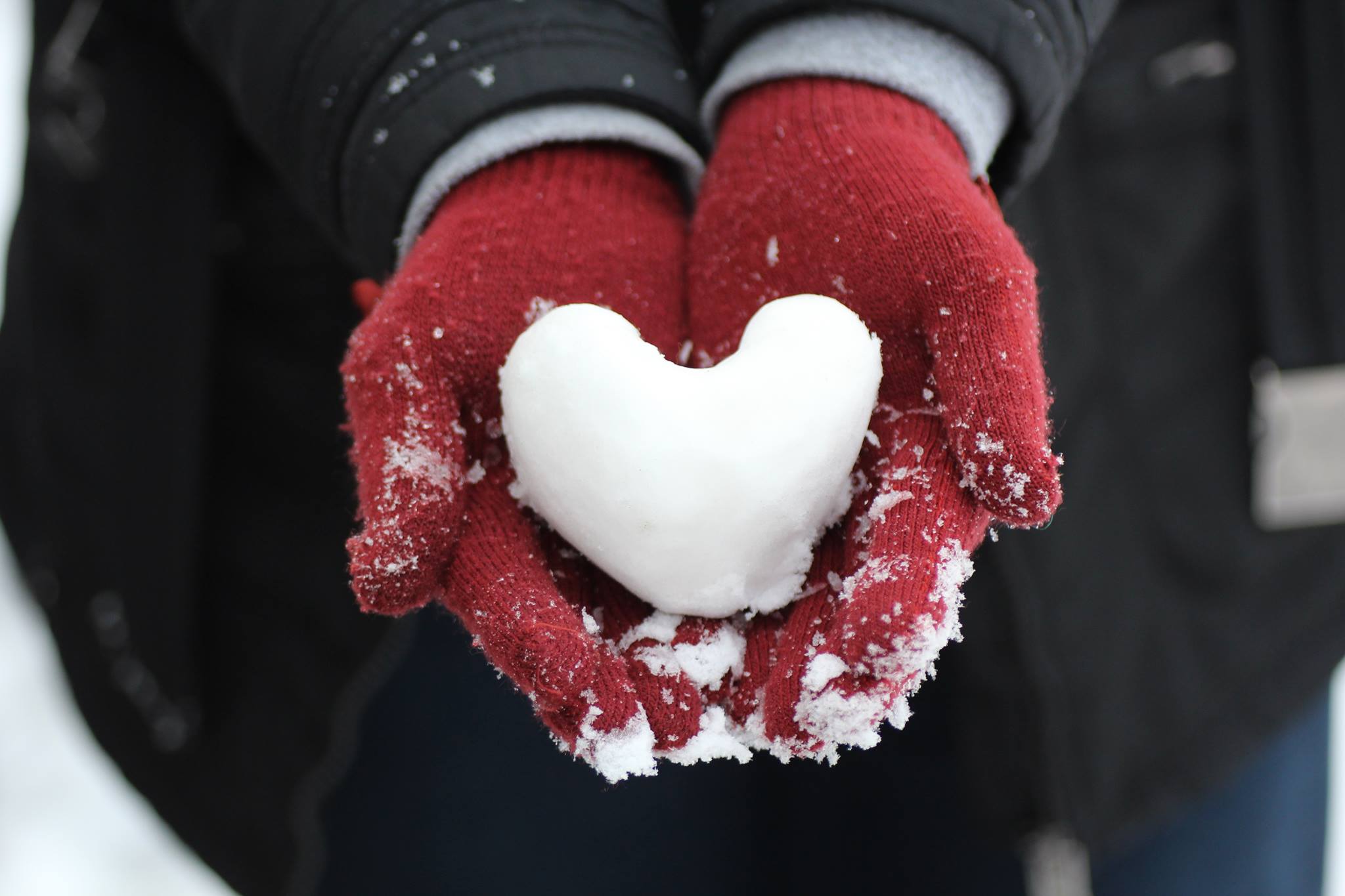 Lähikuva kädessä olevasta lumesta tehdystä sydämestä.