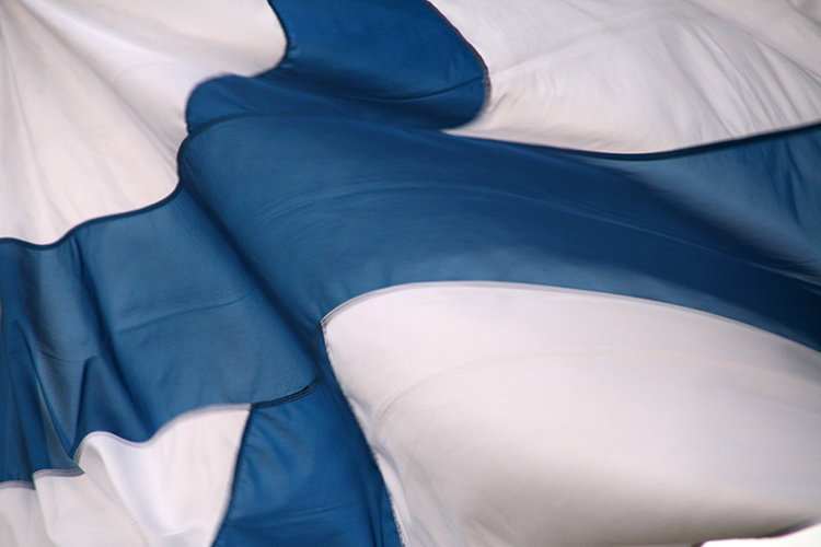 Lähellä oleva tuulessa hulmuava Suomen lippu 