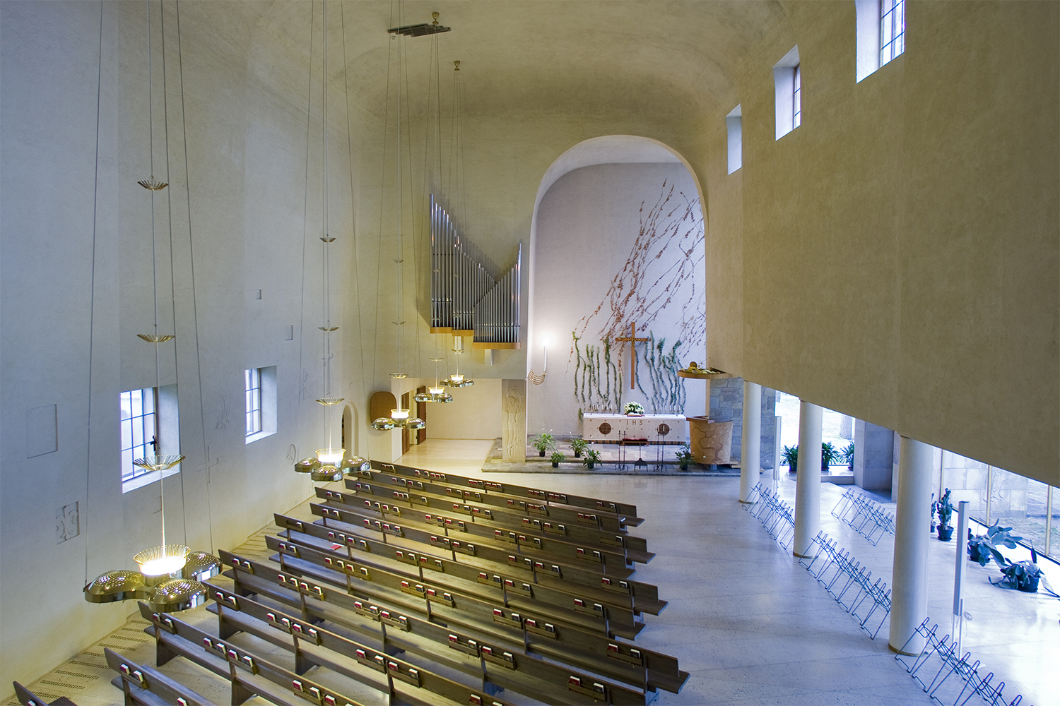 A chapel hall with wooden chair rows and a small altar in front of them. Photo: Timo Jakonen.